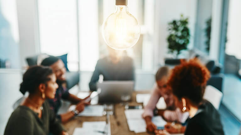 Workers brainstorming around table in conference room