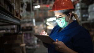 Maintenance worker in mask using tablet