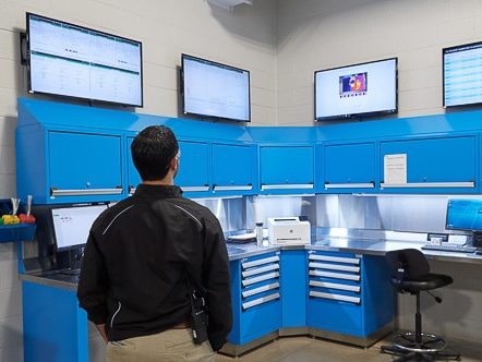 man in black coat looks at thermal data dashboards